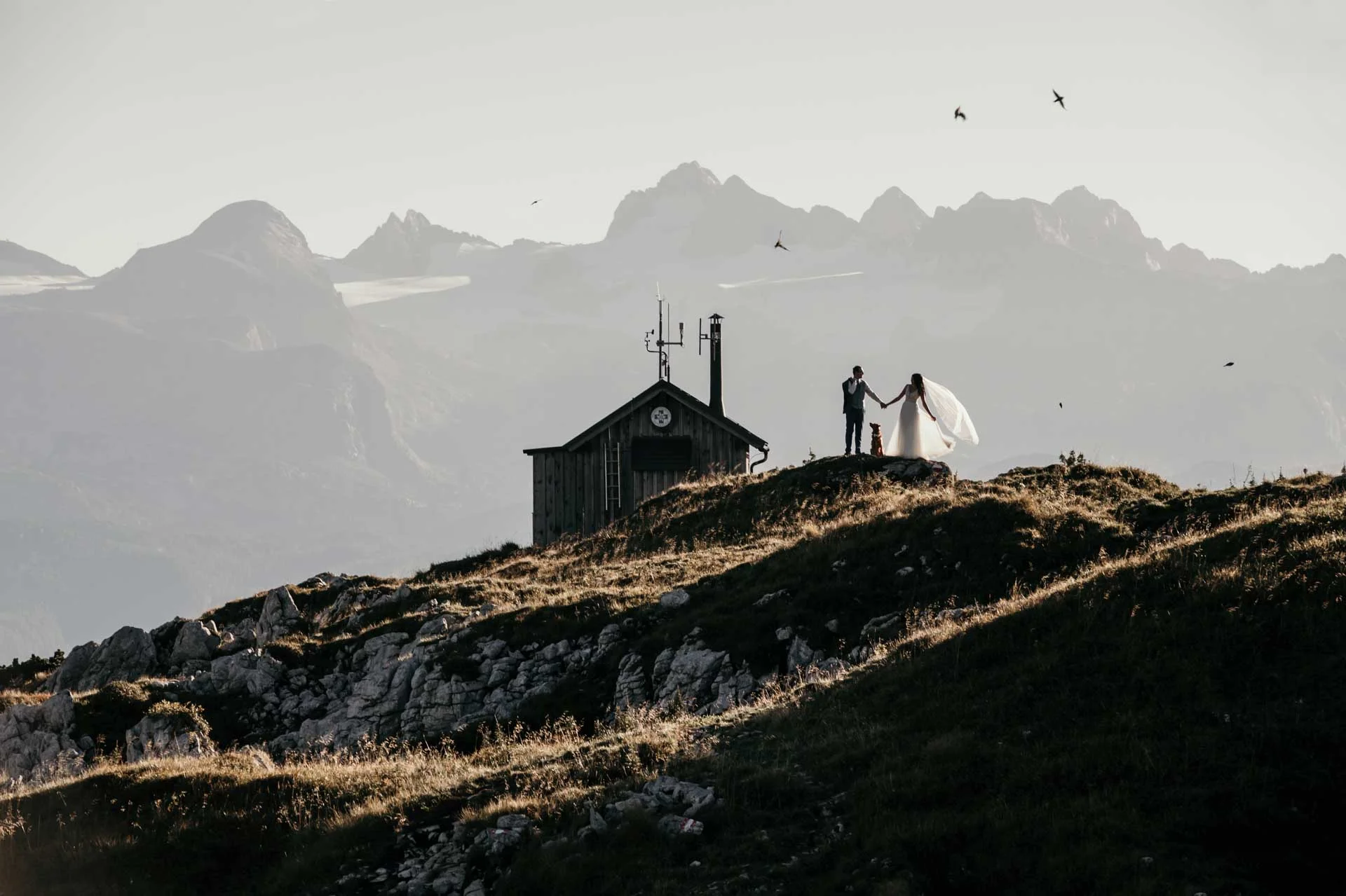 Couple with a dog at a mountain hut in the Alps
