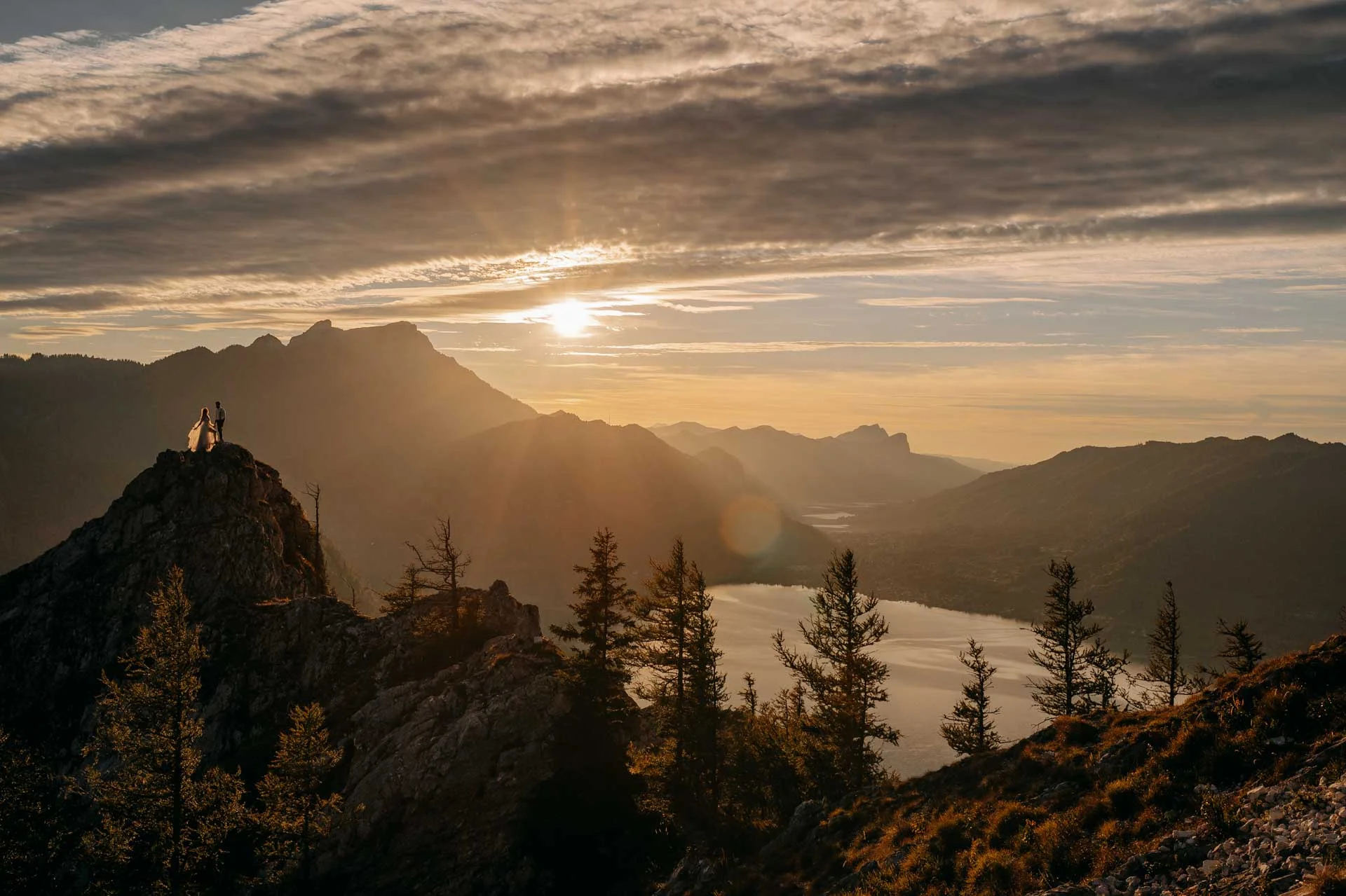 Couple on a rocky ridge above an alpine lake